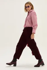 Bota tipo chelsea de cuero charolado color bordó, con caña media, elásticos laterales negros y taco cuadrado bajo.