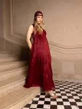 Vestido largo color marrón con bordados florales a tono, escote en V y corte imperio. Tiene falda amplia con volados y breteles finos.