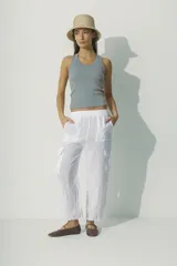 Pantalón de lino blanco, de corte recto y tiro alto, con bolsillos laterales y traseros.