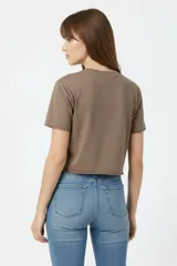 Remera cropped de algodón negra con cuello a la base, mangas cortas y estampado frontal de cerezas con la palabra "HELLO".