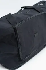 Bolso de viaje tipo duffle, color negro, con cierre principal superior, bolsillo frontal con cierre y doble asa de mano.