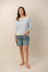 Sweater de tejido de punto a rayas horizontales celestes y blancas, con cuello bote, mangas largas y terminaciones en color amarillo.