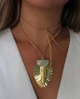 Gargantilla con tira de cuero sintético color beige, dije colgante de bronce con forma de hoja y detalle de nácar en la parte superior.