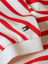 Chomba de piqué de algodón elástico a rayas horizontales rojas y blancas, con cuello tipo polo y escote en V.