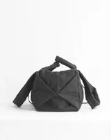 Bolso tipo tote color beige con diseño acolchado y doble asa de hombro.