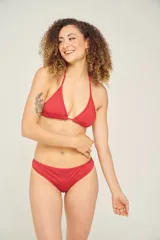 Traje de baño de dos piezas color rojo, compuesto por un corpiño triangular con frunce ajustable y una bombacha clásica.