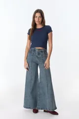 Pantalón de jean celeste con corte acampanado, tiro alto y costuras verticales al frente.