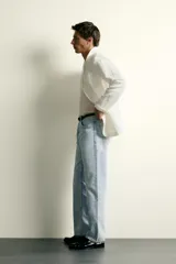 Pantalón jeans de corte recto, color celeste claro con efecto lavado, de cinco bolsillos y tiro medio.