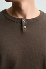 Jersey de punto con mezcla de algodón y cashmere, de corte regular y manga larga. Presenta cuello redondo con cierre frontal de dos botones y acabados en rib.