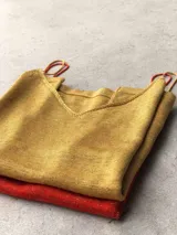 Musculosa de punto color dorado, con escote en V y breteles finos regulables.