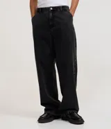 Pantalón de jean azul oscuro de corte super baggy, con diseño holgado, tiro medio y efecto marmoleado. Cuenta con bolsillos laterales y trabillas para cinturón.