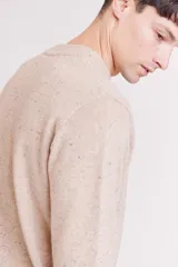 Sweater de punto con cuello redondo, diseño jaspeado en tono beige y puños y ruedo acanalados.