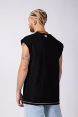 Musculosa oversize de algodón estilo sudadera, color crudo, con costuras visibles en contraste en color negro que recorren el centro verticalmente y enmarcan el cuello y el ruedo.