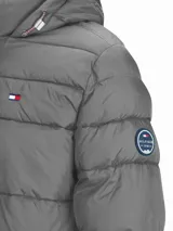 Campera puffer acolchada Tommy Hilfiger de color gris con capucha ajustable, cierre frontal de cremallera, bolsillos laterales con cierre y logo bordado en el pecho.