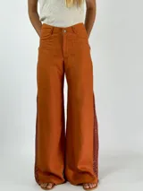 Pantalón de lino color beige, corte palazzo, con detalle de crochet en el lateral inferior.