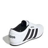 Championes Adidas modelo Tekwen, diseño sin cordones inspirado en el tenis, con capellada sintética blanca, las icónicas tres tiras laterales en negro y lengüeta de malla. Cuenta con entresuela de EVA para mayor amortiguación y suela de goma.