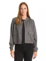 Campera tipo bomber color beige, con cuello redondo, cierre frontal con botones a presión y bolsillos delanteros. Presenta puños y ruedo acanalados.