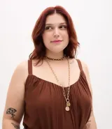 Mono largo de viscosa color marrón, con escote redondo fruncido, tirantes finos y cintura ajustable con lazo del mismo tejido. Presenta un corte holgado y fluido en las piernas.