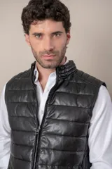 Chaleco de cuero negro con cierre frontal y cuello mao. Diseño acolchado horizontal.