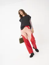 Pantalón de cuero a dos colores con cortes curvos, color rosa y rojo.