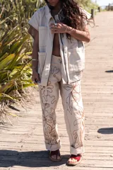 Pantalón slouchy color beige de gabardina de algodón con bordado floral marrón.