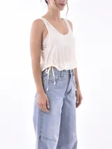 Musculosa negra de tela semitransparente, con cuello redondo y ajuste lateral mediante cordones.