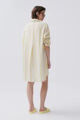 Camisa celeste y blanca a rayas verticales, de calce holgado y hombro caído, con botones al frente.