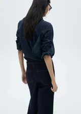 Pantalón de jean estilo wideleg color azul oscuro, con tiro medio, cuatro bolsillos y cinturón incorporado con hebilla metálica.
