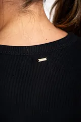 Remera negra de manga larga, con cuello redondo y tejido acanalado, de corte ajustado al cuerpo.