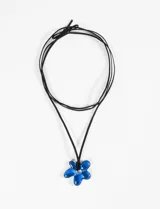 Collar con cordón azul oscuro y dije colgante de flor tridimensional de acrílico o vidrio soplado en tono azul verdoso.