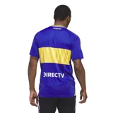 Camiseta de fútbol Adidas del Club Atlético Boca Juniors, modelo titular 2024/2025. Presenta el diseño clásico en color azul con la franja horizontal amarilla en el pecho, cuello en V y las tres tiras características de la marca en los hombros. Incluye el logo de Adidas y el escudo del club bordados, junto con el sponsor oficial estampado en el frente.