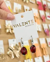 Aros de argolla pequeña de acero con dije colgante de piedra irregular en tono rojizo con vetas oscuras.