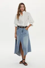 Camisa blanca de cuello mao con volados, mangas abullonadas y cierre frontal con botones.