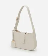 Cartera baguette pequeña color marrón con textura en relieve, correa ajustable, cierre con cremallera y solapa con detalle de colgante.