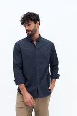 Camisa de gabardina azul marino con efecto stone wash, doble bolsillo frontal con solapa y botón, y fit regular.