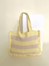 Bolso tipo tote tejido a crochet con hilo de algodón color marrón y crudo, con diseño a rayas horizontales y volados en los bordes.