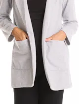 Blazer de tejido soft color beige, con silueta relajada y corte largo. Presenta cuello con solapas muesca, frente abierto sin botones y dos bolsillos de parche frontales.