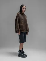 Hoodie oversize de algodón con efecto desgastado y oxidado. Presenta costuras expuestas, detalles de roturas en los bordes, capucha y bolsillo frontal tipo canguro.