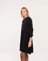 Vestido corto marrón con cuello camisero, abotonado en el frente, mangas largas con elástico en los puños y falda escalonada con volados.