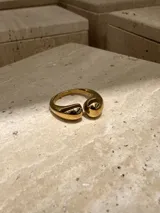 Anillo abierto de acero quirúrgico con diseño de superficie irregular y acabado brillante.