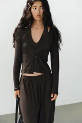 Top de punto efecto doble color gris melange, con diseño de cuello en pico, tirantes tipo halter interiores y cierre frontal con botones. Cuenta con mangas largas.