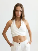 Top blanco de lino con escote halter cruzado y espalda descubierta.