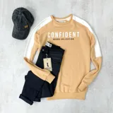 Buzo color naranja con mangas ranglan blancas y texto estampado en el frente.