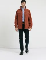 Pantalon de pana de corte recto con diseño de cinco bolsillos, incluyendo bolsillos traseros de parche y cierre con botones y remaches metálicos.