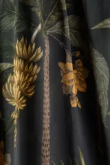 Pollera larga de corte holgado, color negro, con estampado tropical de hojas y flores en tonos verdes y ocres. Presenta tiro alto, cintura elastizada en la espalda con frunces y diseño fluido.