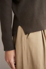 Sweater de punto acanalado color marrón, con cuello polo y escote en V, de manga larga y calce holgado.