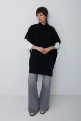 Poncho de tejido de punto color caramelo con cuello alto y diseño holgado sin mangas.
