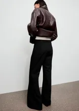 Pantalón flare de tiro alto color negro, con diseño largo y cierre de cremallera lateral.