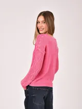 Buzo de tejido de punto color verde menta, con cuello en V y diseño de trenzas en el frente y mangas. Presenta un efecto desgastado o lavado.