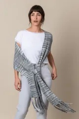 Chal de hilo artesanal color verde con detalles en gris y blanco, con flecos en los extremos y presilla para sujetarlo.